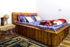 Rustic wooden bed at Riverside Dwelling an offbeat Homestay in Darjeeling